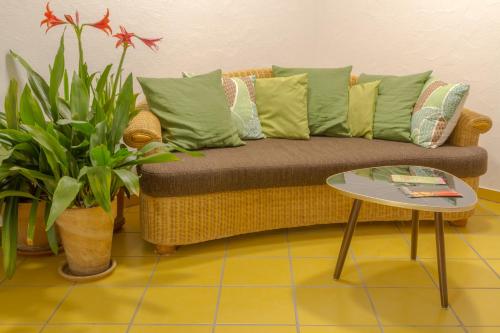 a living room with a couch with pillows and a table at Bio Hotel Haus am Weinberg in Achkarren