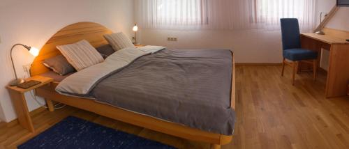 a bedroom with a large bed with a wooden headboard at Bio Hotel Haus am Weinberg in Achkarren