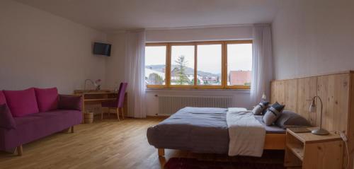 a bedroom with a bed and a purple couch at Bio Hotel Haus am Weinberg in Achkarren