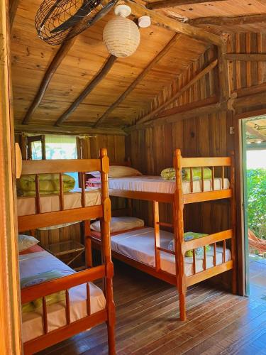 a bedroom with two bunk beds in a cabin at Haleakala Hostel & Pousada in Praia do Rosa