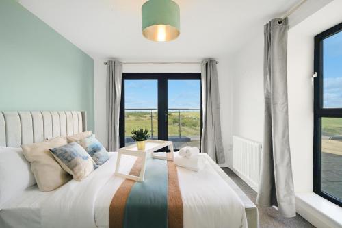 a bedroom with a bed and a large window at Affordable 1 & 2 Bed Apartments in Slough, Great Heathrow Location in Colnbrook