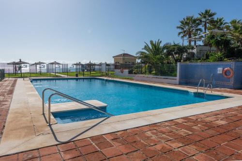 a swimming pool with a hand rail in a yard at Stunning Beachfront Penthouse in Estepona