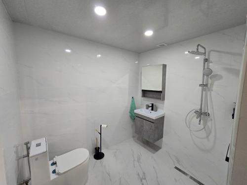 un bagno bianco con lavandino e doccia di Апартаменты a Tsaghkadzor