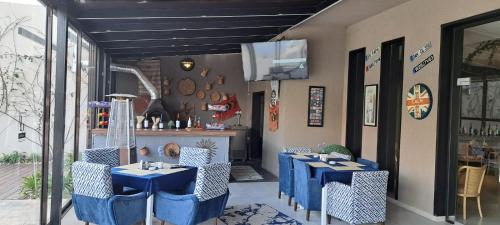 a restaurant with blue tables and chairs and a tv at Aitch Boutique Hotel - an LIH Hotel in Madaba