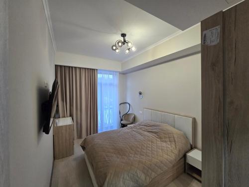 una piccola camera da letto con un letto e una finestra di Апартаменты a Tsaghkadzor