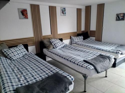 three beds in a room with plaid sheets at Max in Żukowo