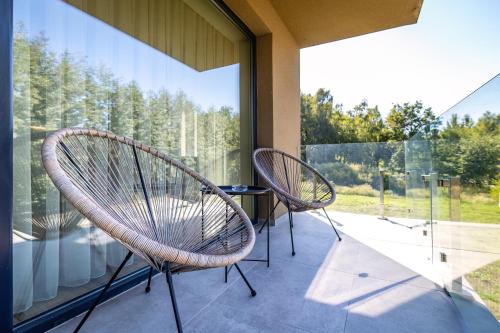 a patio with two chairs and a table on a balcony at Optimus Residence in Balatonföldvár