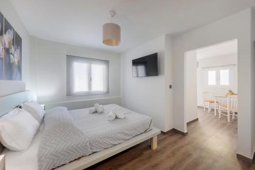 a white bedroom with a bed with towels on it at Aegean Paradiso Vacation Club - "Adults Only" in Azolimnos