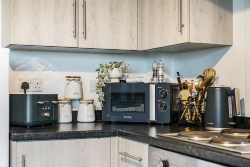 a kitchen counter with a microwave and appliances on it at Affordable 1 & 2 Bed Apartments in Slough, Great Heathrow Location in Colnbrook