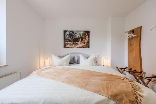 a white bedroom with a large white bed at "Harzträume No3" mit Parkplatz - 2 SZ - Smart TV - Sitzplatz im Freien in Wernigerode