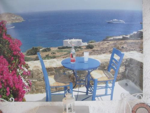 une table et des chaises bleues avec vue sur l'océan dans l'établissement Meletis Studios, à Parikia