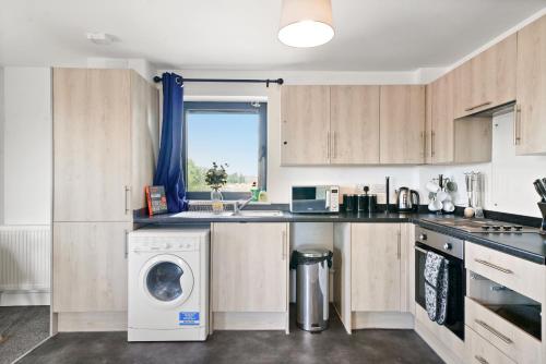a kitchen with a washer and a washing machine at Affordable 1 & 2 Bed Apartments in Slough, Great Heathrow Location in Colnbrook