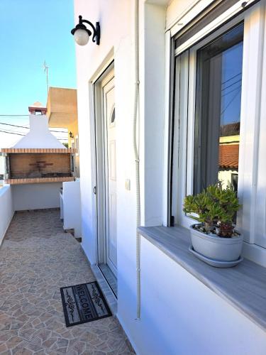 a balcony with a window with a plant in a pot at Guest House Alepou Leros in Alinda