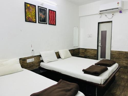 two beds in a room with white walls at Gotawala Villa 11 in Daman