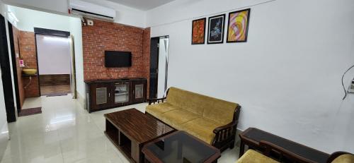 a living room with a couch and a tv at Gotawala Villa 11 in Daman