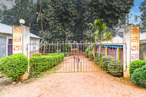 a gate in front of a building with trees at Hotel O MANTRA in Krishnanagar