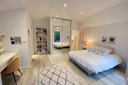 une chambre avec un lit, un bureau et un miroir dans l'établissement Superb contemporary villa with pool and garden, à Roquefort-les-Pins