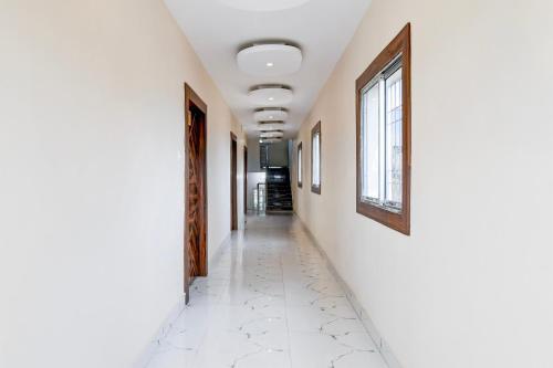 an empty hallway with white walls and a window at Hotel O AB Residency in Āsansol
