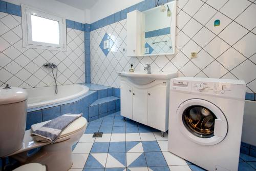 a blue and white bathroom with a washing machine at Villa Rafailia in Skala Marion
