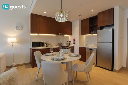 a kitchen and dining room with a table and chairs at HiGuest - Elegant 1BR Oasis in La Mer in Dubai