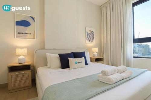 a bedroom with a bed with towels on it at HiGuest - Elegant 1BR Oasis in La Mer in Dubai