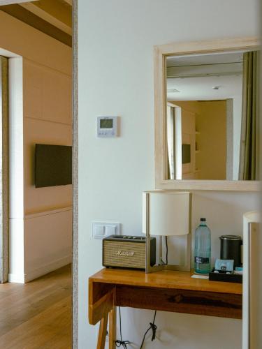 a mirror over a wooden table with a sink at Hostal Empúries in L'Escala