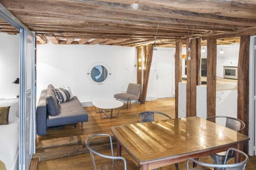 un salon avec une table, des chaises et un canapé dans l'établissement Petit Chalet, à Paris