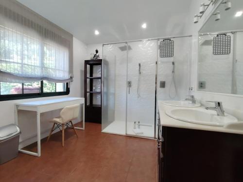 a bathroom with a shower and two sinks and a shower at Villa Alilacha - Piscina Barbacoa Playa 500 m in Bueu