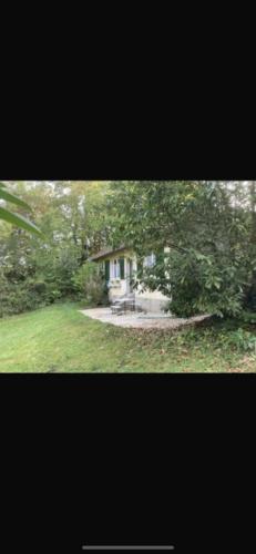 une maison avec une table de pique-nique dans une cour dans l'établissement Maison charmante bordée de bambous, à Auffargis