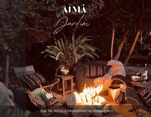 a fire pit with chairs and a table with fires at Alma Hotel in Campos do Jordão
