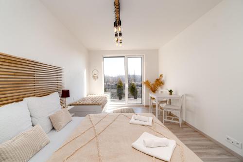 a white bedroom with a large bed and a desk at New BNB Apartment In the Ostrava with parking option in Slezská Ostrava