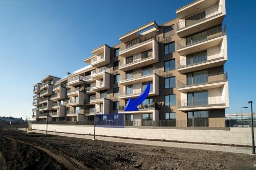 a tall apartment building with a blue arrow at New BNB Apartment In the Ostrava with parking option in Slezská Ostrava