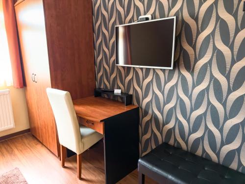 a room with a desk and a television on a wall at Barackvirág Vendégház in Tihany