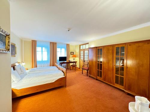 a bedroom with a bed and a desk in it at Hotel Haimerlhof in Wolnzach