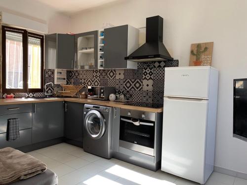 une cuisine avec un lave-linge et un réfrigérateur dans l'établissement Appartement en centre ville, à Corte