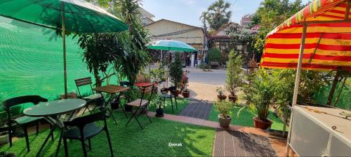 a patio with tables and chairs and an umbrella at MrBean's Place in Siem Reap