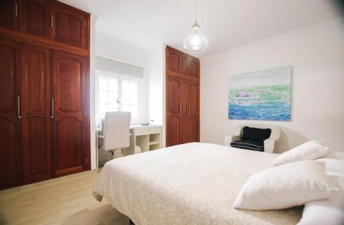 a bedroom with a white bed and a desk at Serenity House in Tinajo