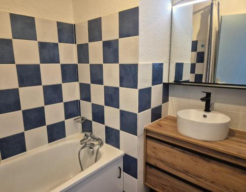 une salle de bain avec un lavabo et une baignoire dans l'établissement Le Petit Flocon - Appt pour 6 vue sur piste, à Villarembert