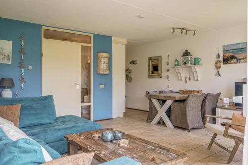 a living room with a blue couch and a table at Appartement Regina - Residence Juliana Julianadorp aan Zee in Julianadorp