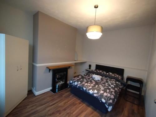 a bedroom with a bed and a fireplace at Double-Bed Manchester Close To Bolton City Centre C1 in Little Hulton