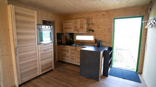 a kitchen with a stove and a sink in a room at Holzhaus am Bergheider See in Buschmühle