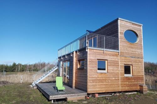 a tiny house with a staircase on a deck at Holzhaus am Bergheider See in Buschmühle