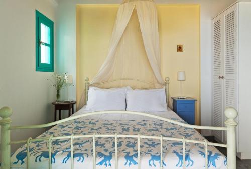 a bedroom with a bed with a canopy at The Iconpainter Marathi Villa in Kómboi