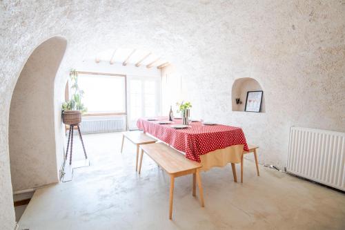 une chambre blanche avec une table et un chiffon rouge dans l'établissement Charmante maison semi-troglodyte, à Amboise