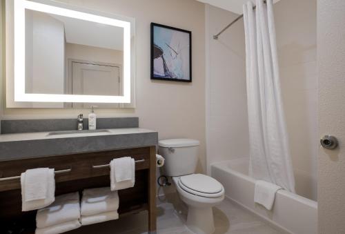 a bathroom with a sink and a toilet and a mirror at Candlewood Suites Lafayette - River Ranch by IHG in Lafayette