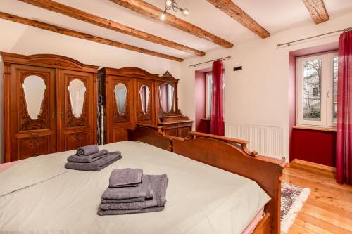 a bedroom with a wooden bed with towels on it at Apartment in GREEN with private SAUNA and WHIRLPOOL Bathtube in Matulji