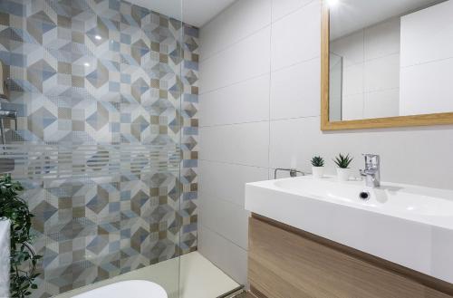 a bathroom with a sink and a toilet and a mirror at Apartments Vistas Mar Bahia in Cádiz