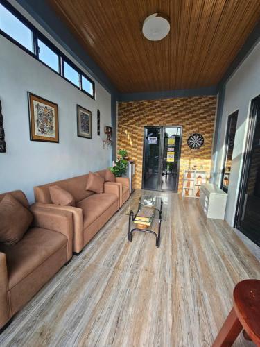 a living room with two couches and a table at Goldland Caelestis Guest House in Bacolod