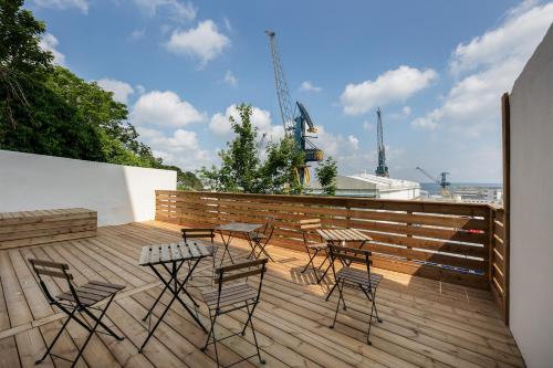 un patio avec des chaises et des tables sur une terrasse en bois dans l'établissement Ribine, à Brest