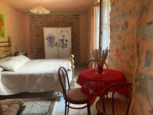 a bedroom with a bed and a table and chairs at La casa del bosco in Bagnone